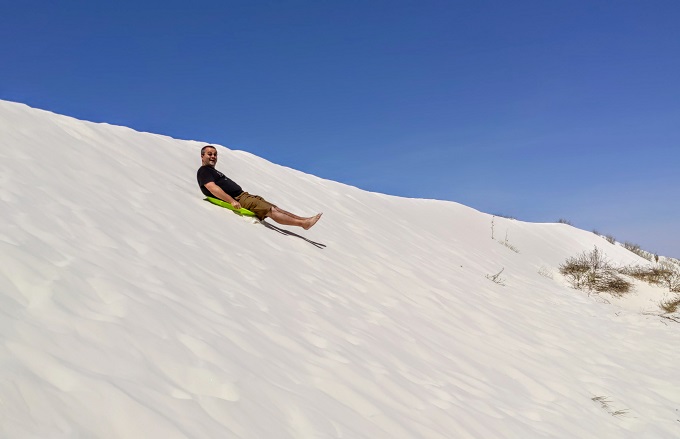 Me sledding down a dune at White Sands National Park