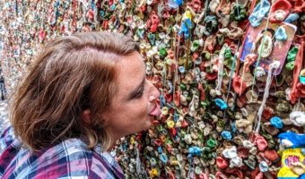 Shae sticking gum on The Gum Wall with her tongue