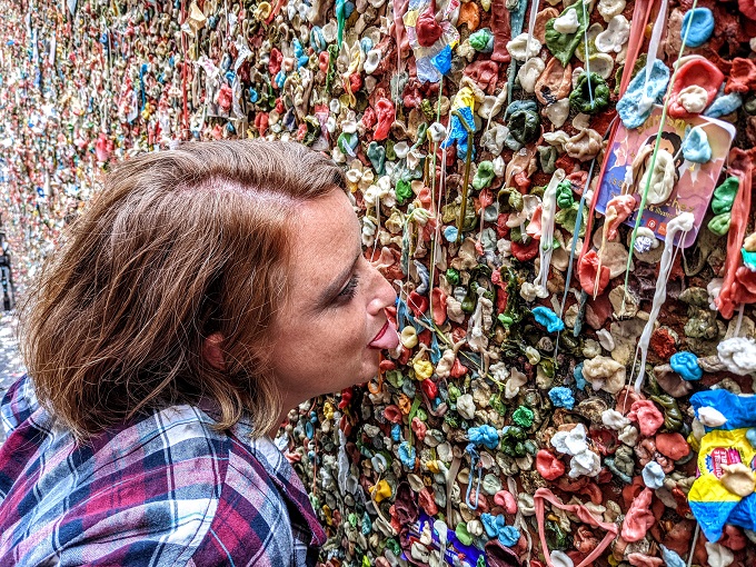 Shae sticking gum on The Gum Wall with her tongue