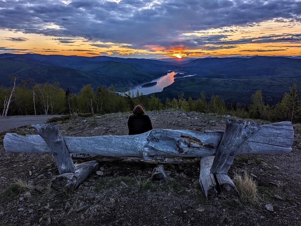 Shae watching the sunset at Midnight Dome Viewpoint in Dawson City