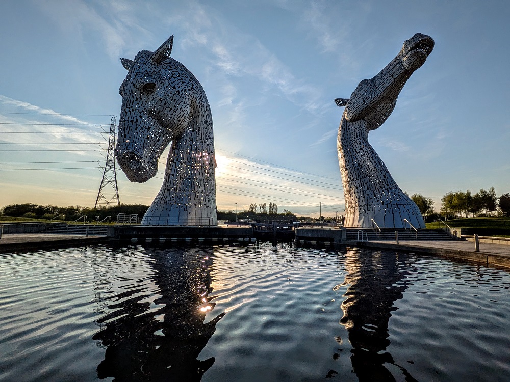 Horse head sculptures in front of a canal